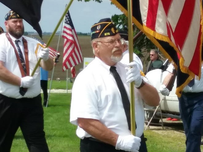 Neponset Post #875 Commander Gary Miller leads a group of members and volunteers in placing 179 large flags at Flora Hill and West cemeteries on Friday. [Submitted]
