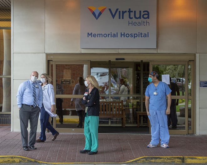 File - Virtua Memorial Hospital Mount Holly health care workers start to come outside to view the solidarity parade in their honor, Wednesday, April 8, 2020. [NANCY ROKOS / PHOTOJOURNALIST]