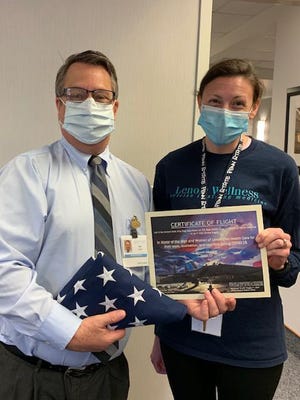 Bob Enders, CEO of UNC Lenoir Helath Care poses with Emily Decker, RD, CDE showing a flag and certificate of appreciation. On May 1 four F-15E Strike Eagles from Seymour Johnson Air Force Base preformed a low altitude flyover to honor Eastern North Carolina Healthcare workers. To commemorate special flights or occasions pilots and WSOs (Weapon System Operators) are able to fly with an American flag in their jet and then present the flag to individuals or groups to show their appreciation. Major John Decker, F-15E Instructor Pilot, worked with the 335th Chiefs Commander and Director of Operations to have an American flag flown over the skies of North Carolina during this tribute for UNC Lenoir Health Care. Along with the flag, a certificate of appreciation was created with signatures from both the pilot and WSO that flew the flag. [Contributed photo]