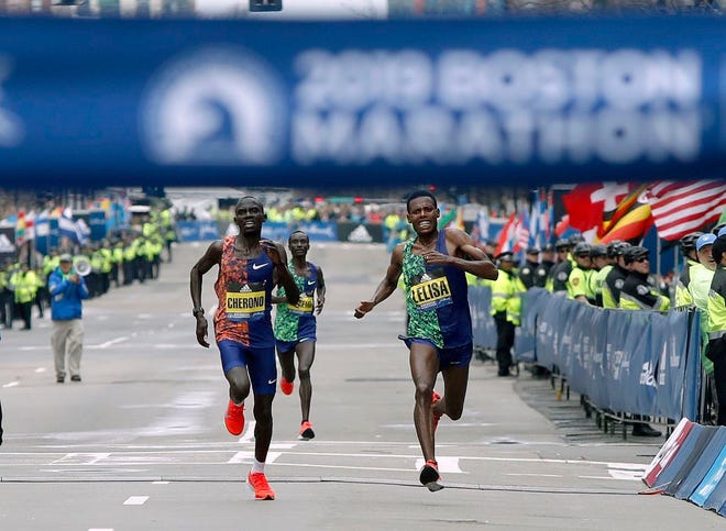Lawrence Cherono, left, of Kenya, runs to the finish line to win the 123rd Boston Marathon in front of Lelisa Desisa, of Ethiopia, right, on Monday, April 15, 2019, in Boston. (AP Photo/Winslow Townson)