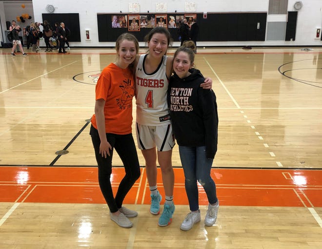 From left, Newton North class president Anabel Marré, captain Adriana Reilly and Isabella Donovan are seen during the school’s Girls Basketball Senior Night, which took place shortly before school was cancelled due to Covid-19. [Courtesy photo]