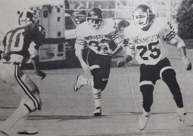 Monmouth’s Scott Farm runs the ball while teammate Jerry Mitchell looks to throw a block. It was more often the other way around during the Zippers’ 1983 state championship season. [SUBMITTED PHOTO]