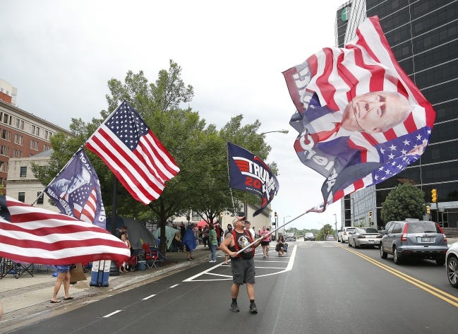 Randal Thom waves a Trump flag Friday in downtown Tulsa. [Sarah Phipps/The Oklahoman]
