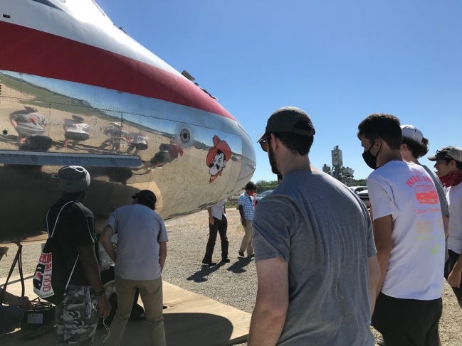 Interns with the Oklahoma State University Unmanned Systems Research Institute inspect an aircraft. USRI partnered with Navatek to fund the internship program, which allows the high school students to work in USRI's lab. [PHOTO PROVIDED]
