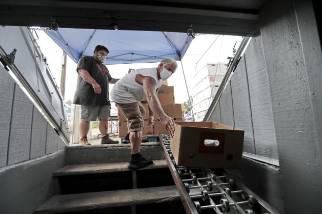 Tyler Melo and Frank Dullea unload a delivery of donations by the Target in Taunton at the PACE (People Acting in Community Endeavors) food bank on William Street in New Bedford. 

[ PETER PEREIRA/THE STANDARD-TIMES/SCMG ]