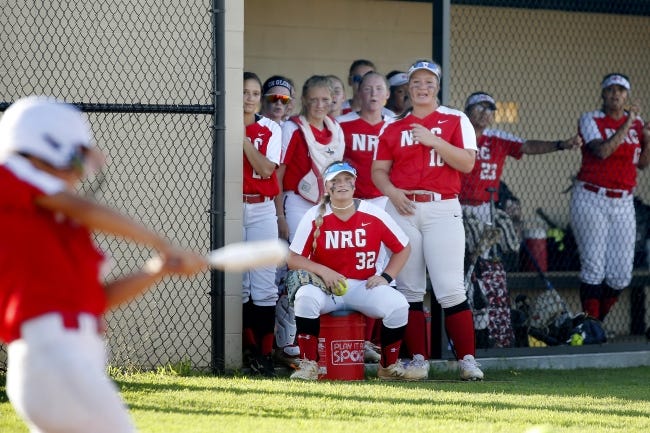 Members of the North Rock Creek softball team watch from the dugout during their scrimmage Friday night in Shawnee. [Bryan Terry/The Oklahoman]