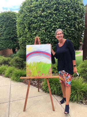 Kellie Brown, Guernsey County Board of Developmental Disabilities superintendent, is pictured with artwork that will be featured at Art Walk. The artwork was created by Amanda Dilley and is titled Rainbow.