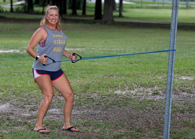 Marlo Alleva demonstrates a standing row with a resistance band. [MICHAEL WILSON/Lakeland Ledger]