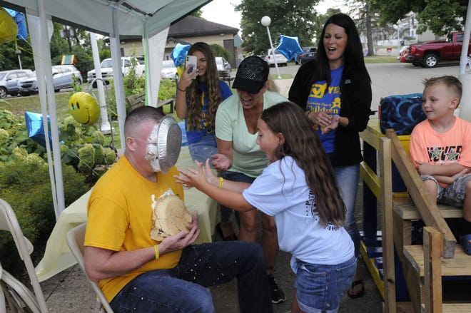Valynn Johnson puts a pie in Guernsey County Sheriff Jeff Paden's face. Johnson asked Paden if she sold 500 cups lemonade could she pie him in the face. She did!