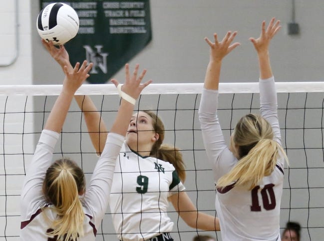 Norman North's Lari Migliorino (9) hits the ball over the net as Edmond Memorial's Alexis Powell (left) and Aubree Johnson defend during a high school volleyball match in October 2019 in Norman. [Sarah Phipps/The Oklahoman]