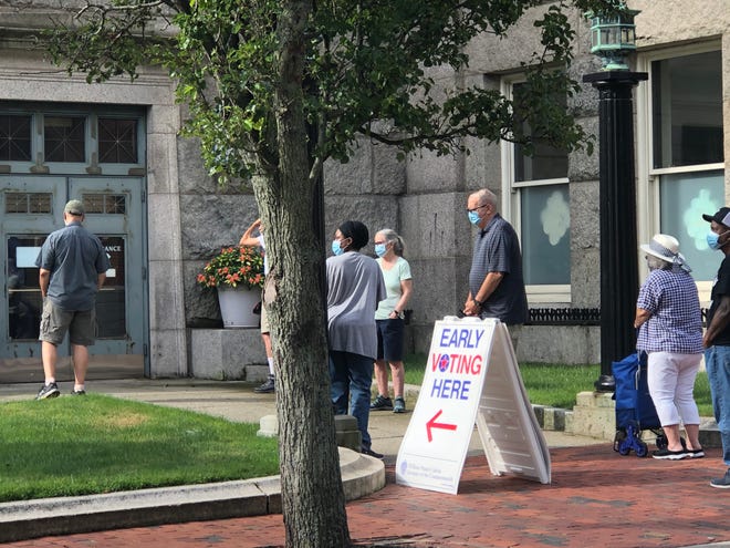 Voters line up outside the downtown public library in New Bedford Saturday morning for early voting. [JACK SPILLANE/THE STANDARD-TIMES/SCMG]