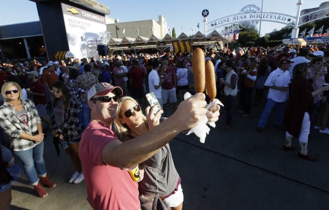 Fletcher's corny dogs are photogenic and a rite of passage for OU and Texas fans every October at the State Fair of Texas outside Cotton Bowl Stadium in Dallas with nearly half a million sold each fall. [AP Photo/LM Otero]