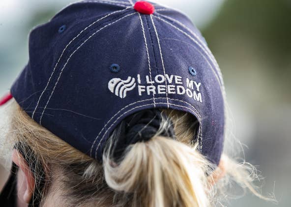 Nancy Delsignore wears a hat reading "I LOVE MY FREEDOM" at the We Back the Blue rally organized by the Middleborough Republican Town Committee at the intersection of Route 28 and Route 105 in Middleboro on Monday, Sept. 28, 2020. [Alyssa Stone/The Enterprise]