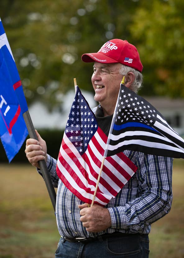 Lifelong Middleboro resident Willy Duphily holds three flags including a large "TRUMP" flag (not pictured) at the We Back the Blue rally organized by the Middleborough Republican Town Committee at the intersection of Route 28 and Route 105 in Middleboro on Monday, Sept. 28, 2020. [Alyssa Stone/The Enterprise]
