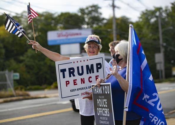 Karen Ioli and Karen Dupily show their support for President Donald Trump and police officers at the We Back the Blue rally organized by the Middleborough Republican Town Committee at the intersection of Route 28 and Route 105 in Middleboro on Monday, Sept. 28, 2020. [Alyssa Stone/The Enterprise]