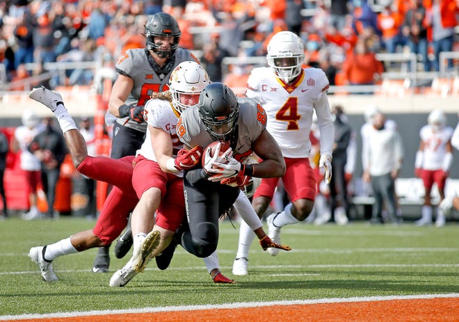 Oct 24, 2020; Stillwater, Oklahoma, USA; 
Oklahoma State Cowboys player Jelani Woods (89) scores a touchdown as Iowa State Cyclones player Mike Rose defends in the first quarter at Boone Pickens Stadium. Mandatory Credit: Sarah Phipps-USA TODAY Sports