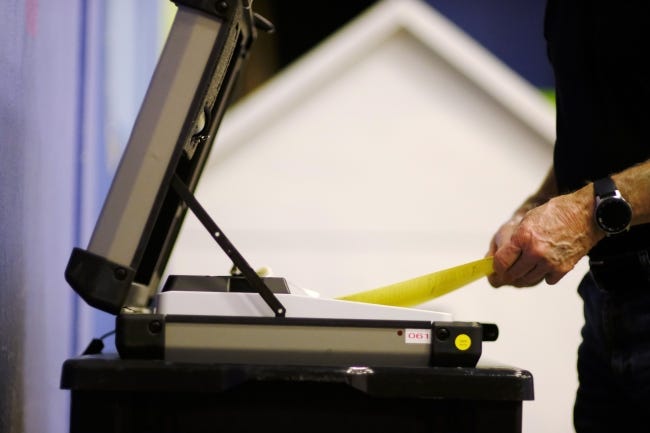 A voter feeds his ballot in the voting machine earlier this year in Edmond. [Doug Hoke/The Oklahoman]