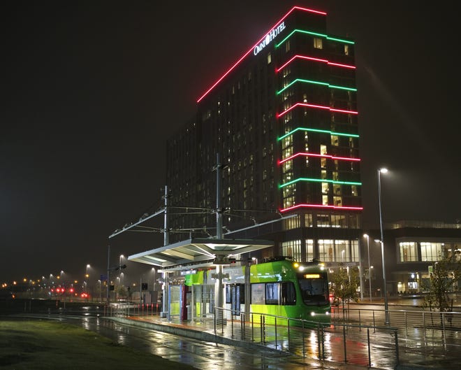 The OKC Streetcar at the Scissortail Park stop, with the soon to open Omni Hotel in the background, in downtown Oklahoma City on a misty, rainy Wednesday night. [Doug Hoke/The Oklahoman]
