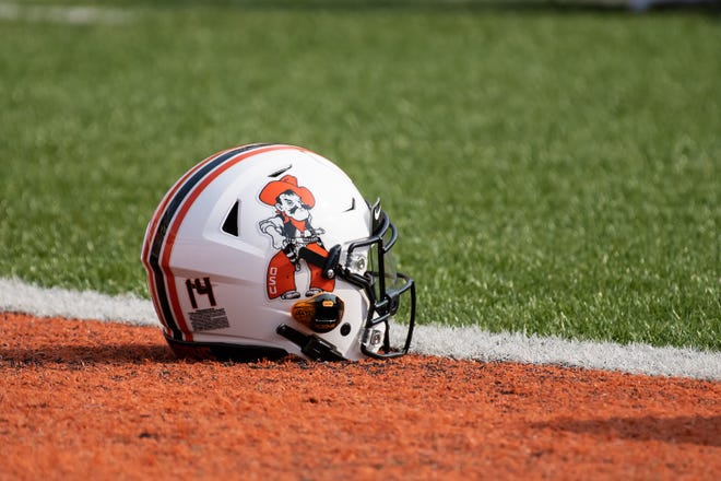 Sep 19, 2020; Stillwater, Oklahoma, USA; Oklahoma State Cowboys helmet lays on the field during warm up before the game Tulsa Golden Hurricane at Boone Pickens Stadium. Mandatory Credit: Rob Ferguson-USA TODAY Sports