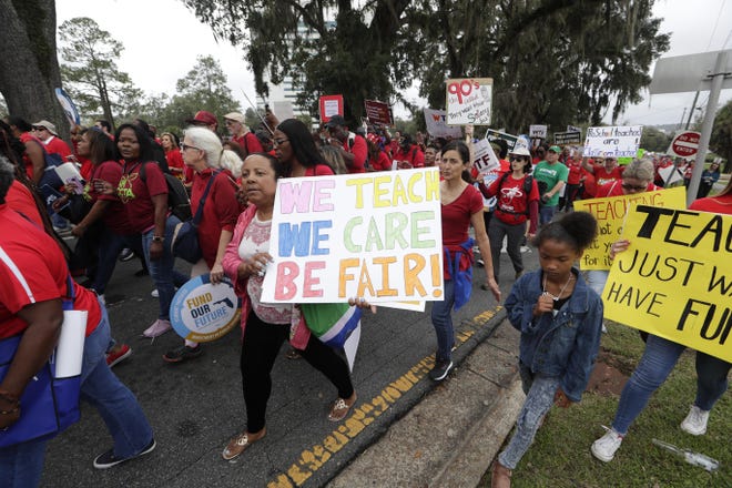 Thousands rallied and marched from the Donald L. Tucker Civic Center to the Florida Historic Capitol on Monday to demand more money for public schools. Thousands of school workers from around the state thronged Florida's Capitol on Monday to press Gov. Ron DeSantis and the Legislature to more than double the nearly $1 billion the governor is proposing for teacher raises and bonuses. [Tori Lynn Schneider / Tallahassee Democrat via AP]