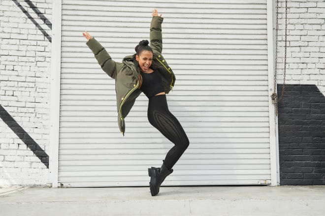 Liza Koshy wearing the Lauren Sculpknit bra with the high-waisted Sculpknit leggings and reversible puffer coat from her new limited-edition capsule collection with Fabletics.