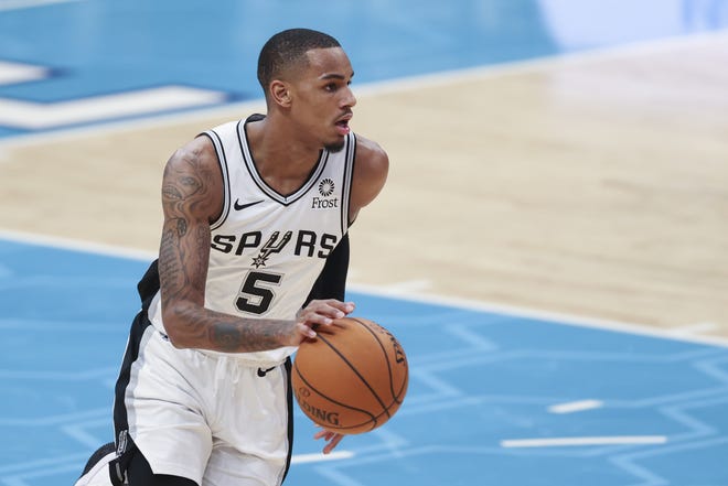 San Antonio Spurs guard Dejounte Murray brings the ball up court during the second half of a game against the Hornets in Charlotte, N.C. The Spurs are dealing with a coronavirus outbreak among four players, the NBA said Tuesday. [AP Photo/Nell Redmond]
