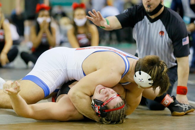 Mustang's Tate Picklo screams as he is injured while wrestling Bixby's Jersey Robb in the Class 6A 195-pound championship match during the state tournament Saturday night at State Fair Arena. [Bryan Terry/The Oklahoman]