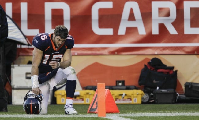 Broncos quarterback Tim Tebow (15) kneels on the sidelines during the third quarter of an NFL wild card playoff win against the Pittsburgh Steelers on Jan. 8, 2012, in Denver. [AP Photo/Joe Mahoney]