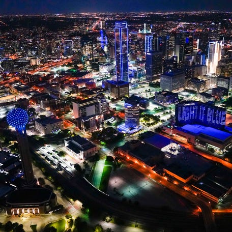 In an aerial vies, buildings in the Dallas skyline are illuminated in blue Thursday, April 9, 2020. Cities and buildings across the nation were lighted in blue to show support for those fighting COVID-19. (Smiley N. Pool/The Dallas Morning News via AP) ORG XMIT: TXDAM321