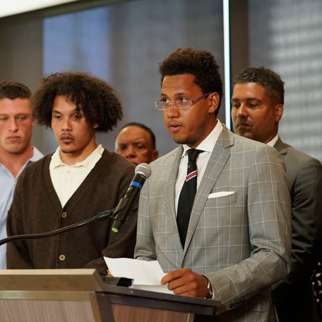 Standing with other former Northwestern athletes, former Northwestern football player Lloyd Yates, right, speaks during a press conference addressing widespread hazing accusations at Northwestern University.