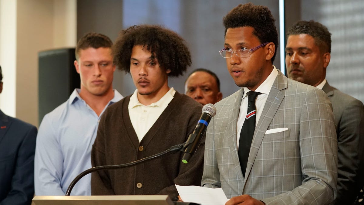 Standing with other former Northwestern athletes, former Northwestern football player Lloyd Yates, right, speaks during a press conference addressing widespread hazing accusations at Northwestern University.