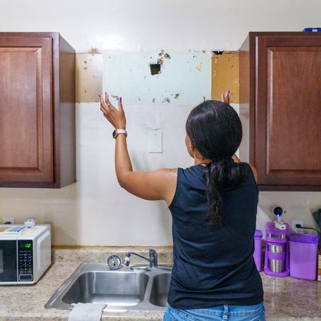 Multiple holes in drywall are seen Thursday, July 20, 2023, inside the kitchen of Vinebrook Homes renter Ayanna White (pictured). White's home, which sits on the east side of Indianapolis, has had numerous issues including an over-the-sink cabinet falling off the wall and onto the head of White. The screws used to hold the cabinet in place completely pulled from the wall. The cabinet still sits unmounted atop White's washer and dryer.