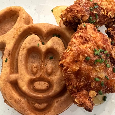 Hand-breaded buttermilk fried chicken is served with a Mickey-shaped malted waffle at Grand Floridian Cafe.