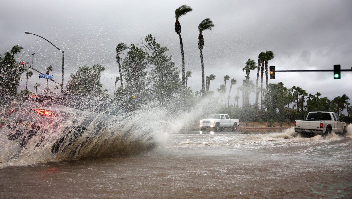 Vehicles drive through a flooded street as Tropical Storm Hilary moves through the area on August 20, 2023 in Cathedral City, California. Southern California is under a first-ever tropical storm warning as Hilary impacts parts of California, Arizona and Nevada.