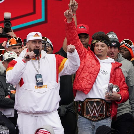 Kansas City Chiefs tight end Travis Kelce speaks as quarterback Patrick Mahomes celebrates during the Super Bowl Champions parade. The teammates are investing in Chicken N Pickle, a pickleball and restaurant chain, that will open in Kansas City.