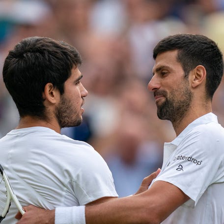 Carlos Alcaraz (left) and Novak Djokovic at the net after the men's final at Wimbledon.
