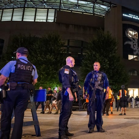 Police officers stand outside Guaranteed Rate Field on Friday night.