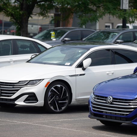 A small collection of unsold 2021 Arteon and Jetta sedans sits in an otherwise empty storage lot outside a Volkswagen dealership in Lakewood, Colo., in this Aug. 1, 2021, photograph.
