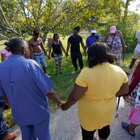 Residents gather for a prayer near the scene of a mass shooting Saturday, Aug. 26, 2023, in Jacksonville, Fla. (AP Photo/John Raoux)