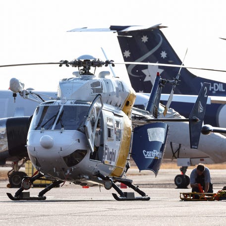 A Care Flight helicopter is seen on the tarmac of the Darwin International Airport in Darwin on August 27, 2023, as rescue work is in progress to transport those injured in the US Osprey military aircraft crash at a remote island north of Australia's mainland.