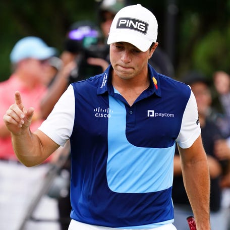 Viktor Hovland waves to the gallery after his putt on the first green during the final round of the TOUR Championship golf tournament at East Lake Golf Club.
