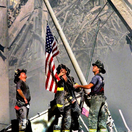 NYC firemen raise the American flag at Ground Zero after the terrorist attacks on the World Trade Center, taken on September 11th, 2001.