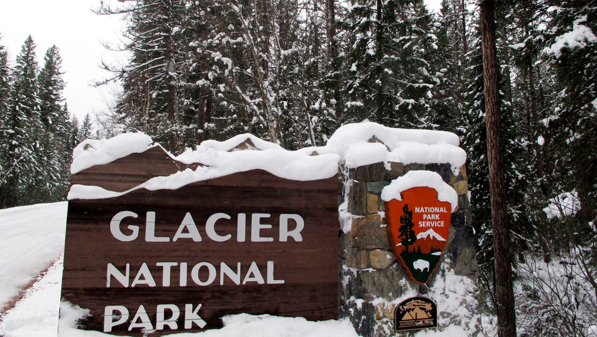 Snow covers the entrance sign to Glacier National Park in West Glacier, Montana, in this file photo from Dec. 11, 2012.