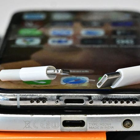 A USB-C charger (R) and a traditional Apple Lightning charger (L) are seen on an Apple iPhone with Lightning port above an Android phone with a USB-C port on September 11, 2023 in Los Angeles. The new Apple iPhone 15, with an EU ordered USB-C charger, was announced during a launch event on September 12, 2023.