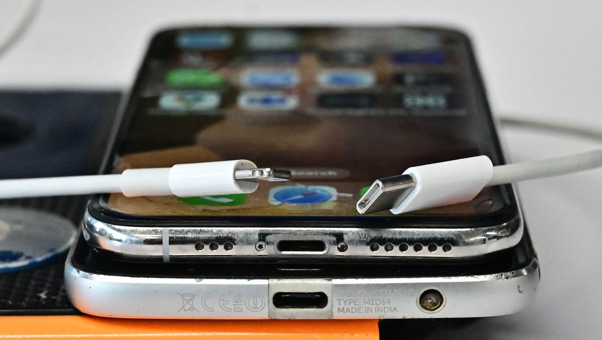 A USB-C charger (R) and a traditional Apple Lightning charger (L) are seen on an Apple iPhone with Lightning port above an Android phone with a USB-C port on September 11, 2023 in Los Angeles. The new Apple iPhone 15, with an EU ordered USB-C charger, was announced during a launch event on September 12, 2023.