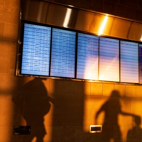 The sunrise casts shadows of travelers moving past gate information screens at Detroit Metropolitan Airport on Labor Day, Monday, Sept. 4, 2023, in Detroit. (AP Photo/David Goldman)