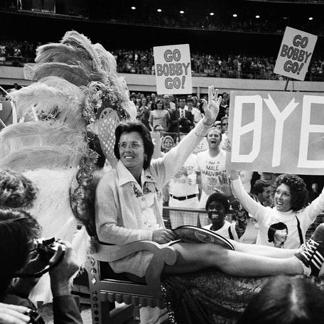 Ms. Billie Jean King waves to crowds at the Astrodome in Houston, Tex., Sep 20,1973 as she is borne onto the crowd on a multi-colored throne carried by four men for her match with Bobby Riggs.
