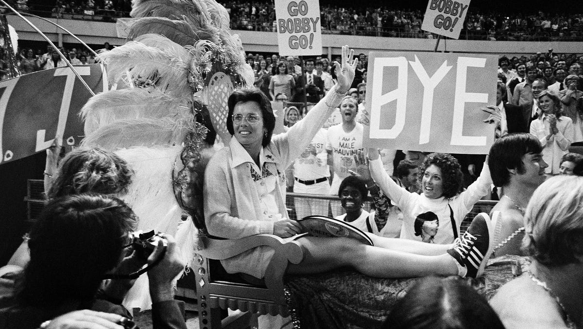 Ms. Billie Jean King waves to crowds at the Astrodome in Houston, Tex., Sep 20,1973 as she is borne onto the crowd on a multi-colored throne carried by four men for her match with Bobby Riggs.