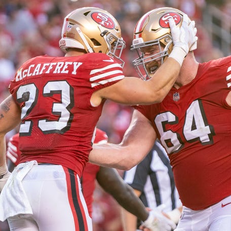 San Francisco 49ers running back Christian McCaffrey (23) is congratulated by center Jake Brendel (64) after scoring a touchdown.