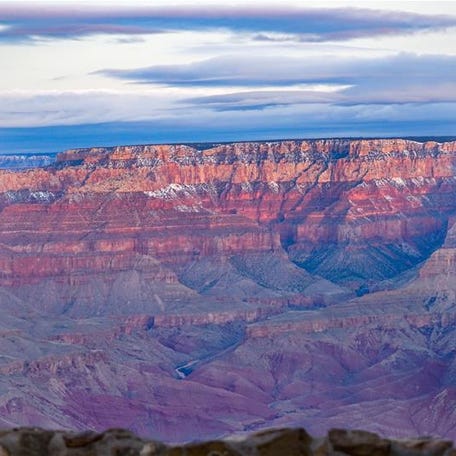 Evening colors and fresh snow on the Grand Canyon's North Rim, frame the Colorado River, which looks like a thin thread in this February 2019 file photo
